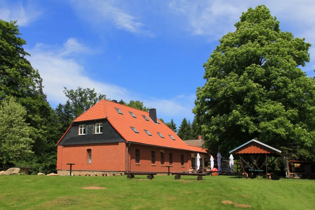 Maison en briques avec toit rouge dans la verdure