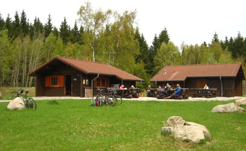 Les cyclistes profitent d'une pause devant la cabane en forêt